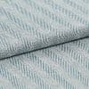 Folded woven textile with diagonal raised ribbed stripes in pale blue and white; fabric overlapped along a central fold; close-up view with soft, even lighting on a neutral surface.