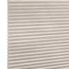 Beige cellular (honeycomb) blind, horizontal pleats with visible hexagonal cells at left edge; closed and diffusing light; photographed in a neutral, evenly lit studio setting with no visible room.