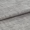 Woven grey curtain fabric folded into overlapping horizontal layers, showing coarse, irregular weave; tight close-up with neutral lighting highlighting texture and subtle tonal variation.