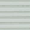 Cellular pleated blinds, fully lowered with evenly spaced pale gray-green horizontal bands, filtering diffuse daylight across a neutral interior and creating soft, uniform illumination.