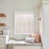 White horizontal slatted blinds within a painted window frame, closed and filtering soft daylight; kitchen nook with cushioned bench, throw and pillows, floating shelves, bread box and neutral decor.
BREAD