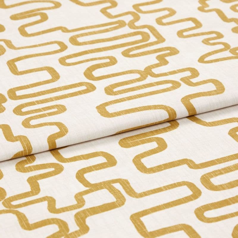 A folded linen-like curtain fabric with mustard-yellow continuous rounded-rectangle print; folded and lying flat, photographed close-up under soft studio lighting showing texture and repeating geometric pattern.