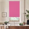 Bright pink roller blind covers most of a kitchen window above the sink and faucet, with a countertop holding a bowl of greens, potted plants, framed sketch on the wall.