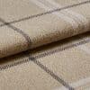 Beige wool plaid blanket with thin dark and white checks, folded in layers; resting on a matching fabric surface; close-up shot emphasizing textured fibers and soft, diffuse lighting.
