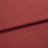 A folded red-brown woven upholstery fabric, folded once across the frame; fine, even weave visible, shown in close-up with soft, even studio lighting.