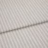 Beige woven fabric with thin vertical gray pinstripes, folded once and overlapping, lying flat as a sample in soft, diffuse lighting—close-up view emphasizing texture and pattern.