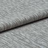 Folded grey woven fabric with raised, wavy ribbed texture (object) layered across itself (action) in a close-up, neutral-lit studio view emphasizing tactile detail (context).