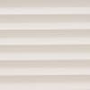 Horizontal cellular blinds with alternating beige and off-white pleats, closed and filtering soft daylight; they cover a window within a neutral interior, producing even, diffuse light and no view.
