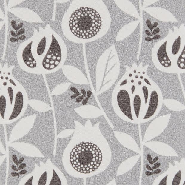 Wallpaper — light-gray, matte textured surface patterned with repeating stylized white and dark-gray pomegranate-like flowers and leaves; the motif repeats uniformly, covering a flat interior wall under even lighting.