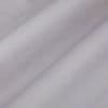 Pale lavender curtain fabric, hanging in soft diagonal folds, gently diffusing light in a neutral, dim interior close-up.