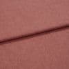 Dusty-rose woven fabric (linen-like), folded once forming a horizontal overlap; textured weave visible, shown in soft diffuse lighting as a close-up flat lay on a neutral surface.