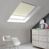 Room with white eaves wall, dark blue-grey wall to right with a shabby chic white drawer unit, a contemporary white chair, white painted floorboards and a skylight blind in ivory.