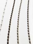 Four vertical blind pull chains — a left white braided cord with spaced beads, a bronze beaded chain and two steel ball chains — hanging straight against a white background, evenly lit.