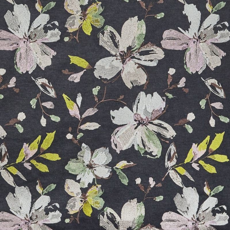 Dark charcoal textile featuring embroidered pastel floral motifs—large, sketchy blossoms and leaves—repeating across the surface, creating a soft, vintage botanical pattern in muted pinks, greens, and yellow.