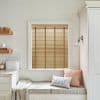 Horizontal wooden slatted blinds with brown ladder tapes — lowered and closed, filtering warm daylight — above a cushioned window seat in a pale, softly lit kitchen nook.
BREAD
THE PIG
