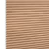 Beige honeycomb (cellular) blind with visible white cell ends at left, closed and blocking light; close-up product shot against a plain white background with even lighting.