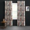 Grommet-top watercolor-patterned curtains, full-length and hung on a metal rod, parted slightly to expose a bright window; dark-painted wall, small wood side table with glass lamp and framed abstract art.
