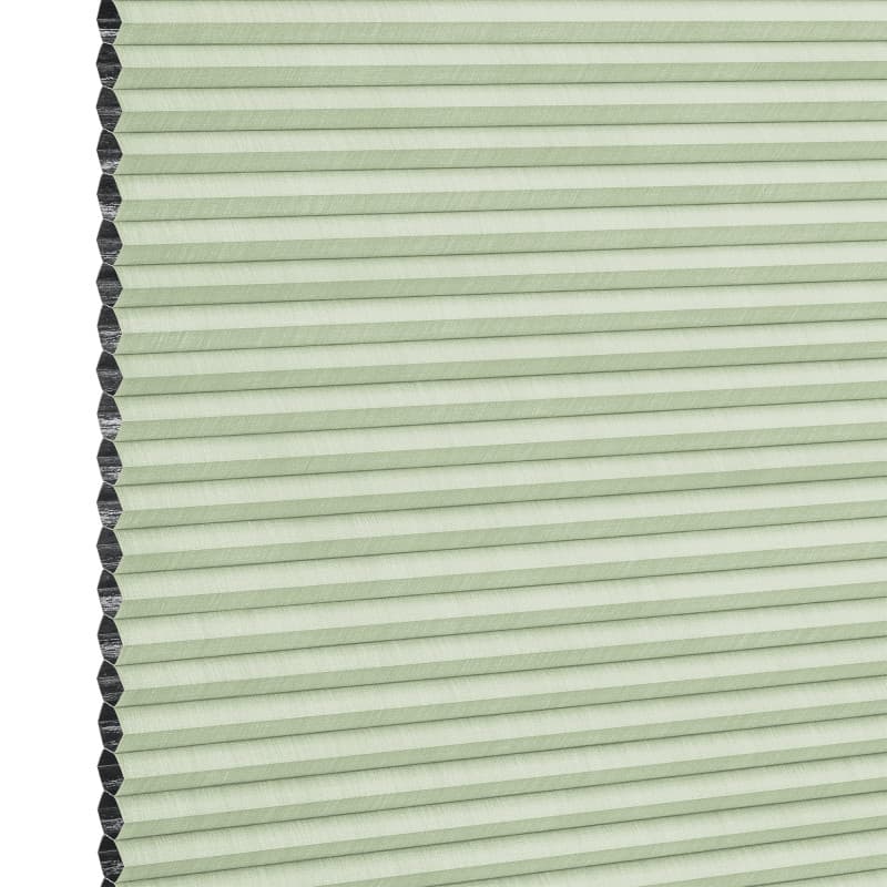 Cellular (honeycomb) blind, pale green with visible black cell edges — closed, pleated and covering the frame — close-up product view with even lighting and a neutral background.
