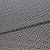 Black-and-white chevron-patterned fabric, folded across the center and showing dense, repeating zigzag lines; lying flat, closely cropped, with even studio lighting highlighting its texture.