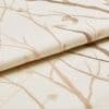 Cream woven fabric with beige embroidered branches (curtain sample), folded to show raised embroidery and textured weave; close-up studio setting with soft, neutral lighting.