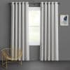 Grommet-top light-gray textured curtains, hanging in panels and parted to frame the window, filtering daylight; modern room with dark gray walls, a gold wire chair and abstract wall art.