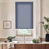 Blue patterned roller blind covers window above kitchen sink, blocking light; surrounding marble countertop holds faucet, bowl of leafy greens, potted plants and a framed sketch on pale wall.