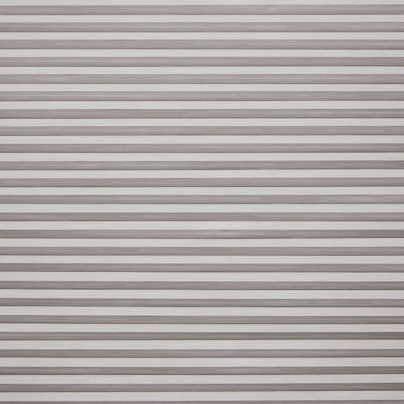 Horizontal slatted roller shutter (narrow, textured beige‑gray metal slats) — fully closed, overlapping — blocking light and view across a window or doorway in neutral indoor lighting.