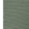 Cellular honeycomb blind — sage-green pleated fabric fully lowered with exposed hexagonal cells along the left edge; blocking and softly filtering light in a neutral interior.