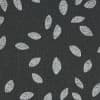 Dark charcoal woven fabric patterned with scattered white, textured leaf-shaped ovals; motifs roughly evenly spaced, creating a repeating decorative design; close-up, flat diffuse lighting and no visible surroundings.