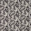 Cream palm-leaf patterned wallpaper covering a wall, leaves repeating in diagonal fronds; high-contrast cream-on-black design providing a decorative, flat surface suitable for an interior accent wall.