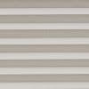 Horizontal pleated cellular shades fully lowered across the window, their alternating light-and-dark bands filtering soft daylight, filling a neutral-toned interior with diffused, even illumination.