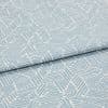 Light blue-and-white patterned fabric with geometric short parallel-stripe blocks; folded with an overlapping edge; close-up on textile surface under soft, even studio lighting.