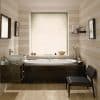 A light-filtering pleated cellular blind fully lowered over the window, softly diffusing daylight into a contemporary striped-wall bathroom with a central soaking tub, wood vanity, mirror, shelf, and chair.