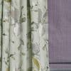 Floral jacquard curtains (left) with soft vertical pleats, hanging and slightly gathered; textured mauve Roman blind (right) folded and lowered; close-up of fabrics in a softly lit interior.