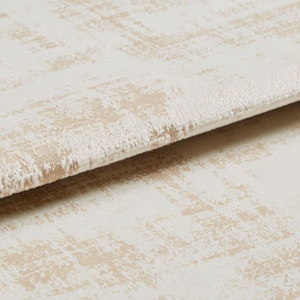 Crushed-velvet fabric with beige abstract pattern—folded and overlapped to reveal nap and edge; close-up, studio-lit view emphasizing soft texture and subtle sheen.