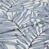 Blue botanical-print fabric (fine woven textile with navy stems and pale blue elongated leaves) folded and layered, edges overlapping; close-up view on a white surface with soft, diffused lighting.