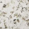 Light linen fabric with watercolor-style floral sprigs in muted olive, gray and black; pattern scattered across the surface, printed close-up, suggesting wallpaper or upholstery in soft, neutral lighting.