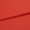 Red woven fabric panel with visible fine texture, folded across the frame forming a horizontal overlap; lying flat under soft, even studio lighting with no other objects or background details.