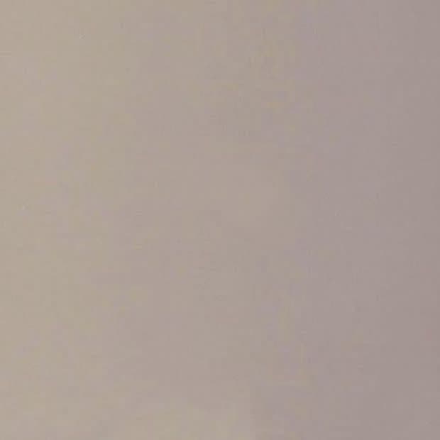 Plain light beige painted wall with subtle texture, filling the frame and evenly lit; minimal indoor setting with soft diffuse lighting and no visible fixtures or decorations.