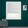 White fabric Roman shade, lowered to mid-window with horizontal folds, filtering soft daylight through lower glass — set in a teal-walled room with white trim, small dresser and framed abstract art.