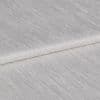 Textured ivory curtain fabric, folded over itself showing horizontal ribbed sheen; close-up view on a neutral surface with soft, diffuse lighting highlighting the weave.