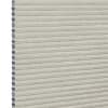 Light beige honeycomb cellular shade with pleated fabric and exposed hexagonal cell ends at left, fully lowered and closed, concealing view; close-up product-style shot on white background with even lighting.