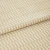 Textured beige-and-cream fabric with raised rectangular stripe pattern, folded once and layered, shown close-up on a neutral surface under soft, even studio lighting.