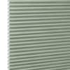 Honeycomb cellular blind with horizontal pleats and white cell edges — fully lowered and closed — pale sage-green fabric, close-up interior view, evenly lit and diffusing incoming light.