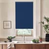 Blue roller blind hangs partially lowered over a window, blocking light; faucet and sink sit beneath on a marble countertop, flanked by wooden cabinets, potted plants and a bowl of greens.